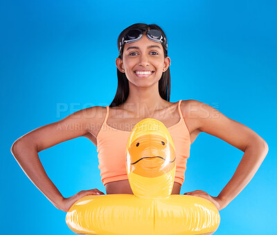 Buy stock photo Happy, pool float and portrait of woman in studio for summer, swimming and holiday. Smile, happiness and beach vacation with female and duck inflatable on blue background safety, playful and funny