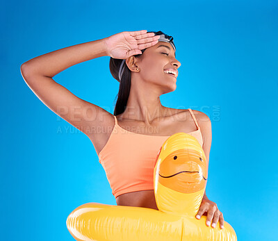 Buy stock photo Rubber duck, smile and salute with a swimmer woman in studio on blue background wearing goggles on her head. Happy, hand gesture and swimming with an attractive young female excited to swim in summer