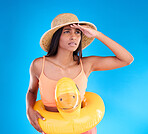 Studio, shocked woman on beach and vacation on blue background, looking or search with hat and hand on face. Travel, pool holiday and worried girl with inflatable rubber duck, ocean wear on holiday.