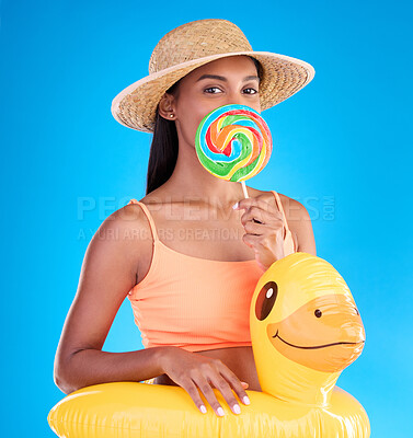 Buy stock photo Portrait, lollipop and rubber duck with a woman on a blue background in studio ready for summer swimming. Happy, travel and vacation with an attractive young female looking excited to relax or swim