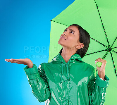 Buy stock photo Sad, looking and a woman with an umbrella for the rain isolated on a blue background in a studio. Confused, insurance and a girl waiting for bad weather, disappointed and feeling for water in winter