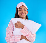 Sleep, happy and a woman hugging a pillow isolated on a blue background in a studio. Smile, comfy and a girl ready for sleeping, nap or slumber in pyjamas for comfort and coziness on a backdrop