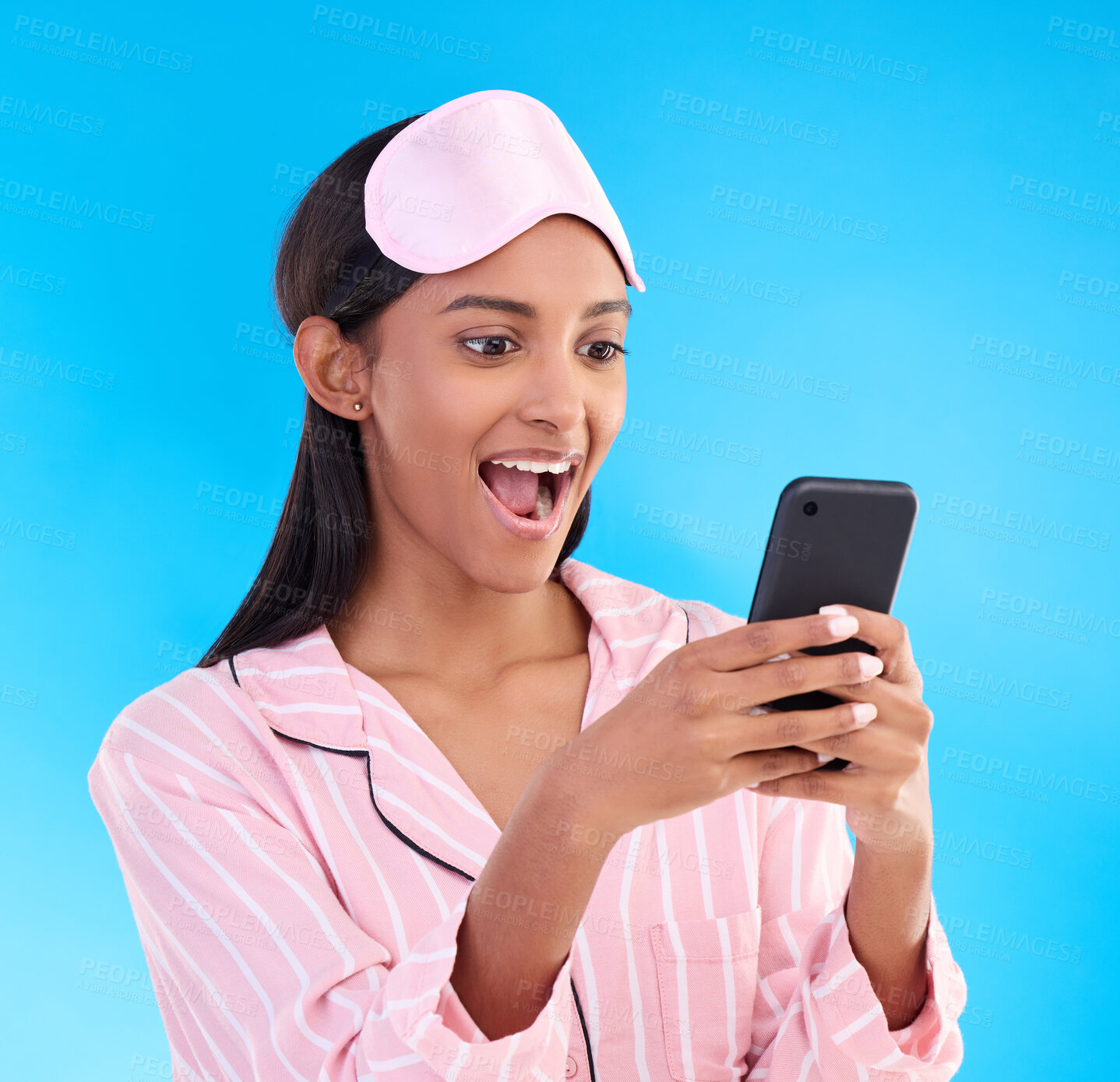 Buy stock photo Pajamas, shocked and woman surprised at her phone due to good news notification isolated in a studio blue background. Excited, cellphone and female with wow expression for a discount or sale