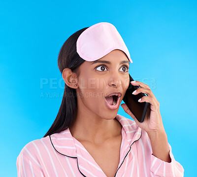 Buy stock photo Phone call, shock and woman in pajamas in a studio with shocking, winning or good news. Surprise, happy and Indian female model on a mobile conversation with a wtf, omg or wow face by blue background
