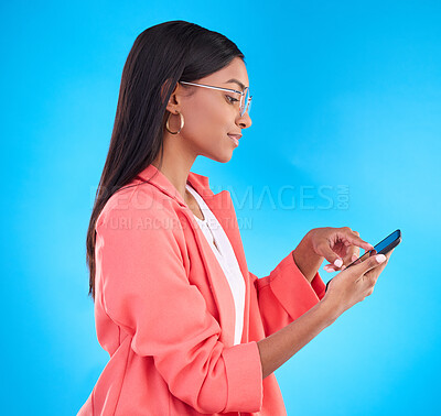 Buy stock photo Woman, phone and fashion in social media, communication or browsing against a blue studio background. Stylish female typing on mobile smartphone app for business, networking or research on mockup