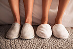 Feet, slippers and together on floor in bedroom, spa or hotel to relax in morning with luxury hospitality. Women, house shoes and carpet in room, apartment and footwear for comfort on home flooring