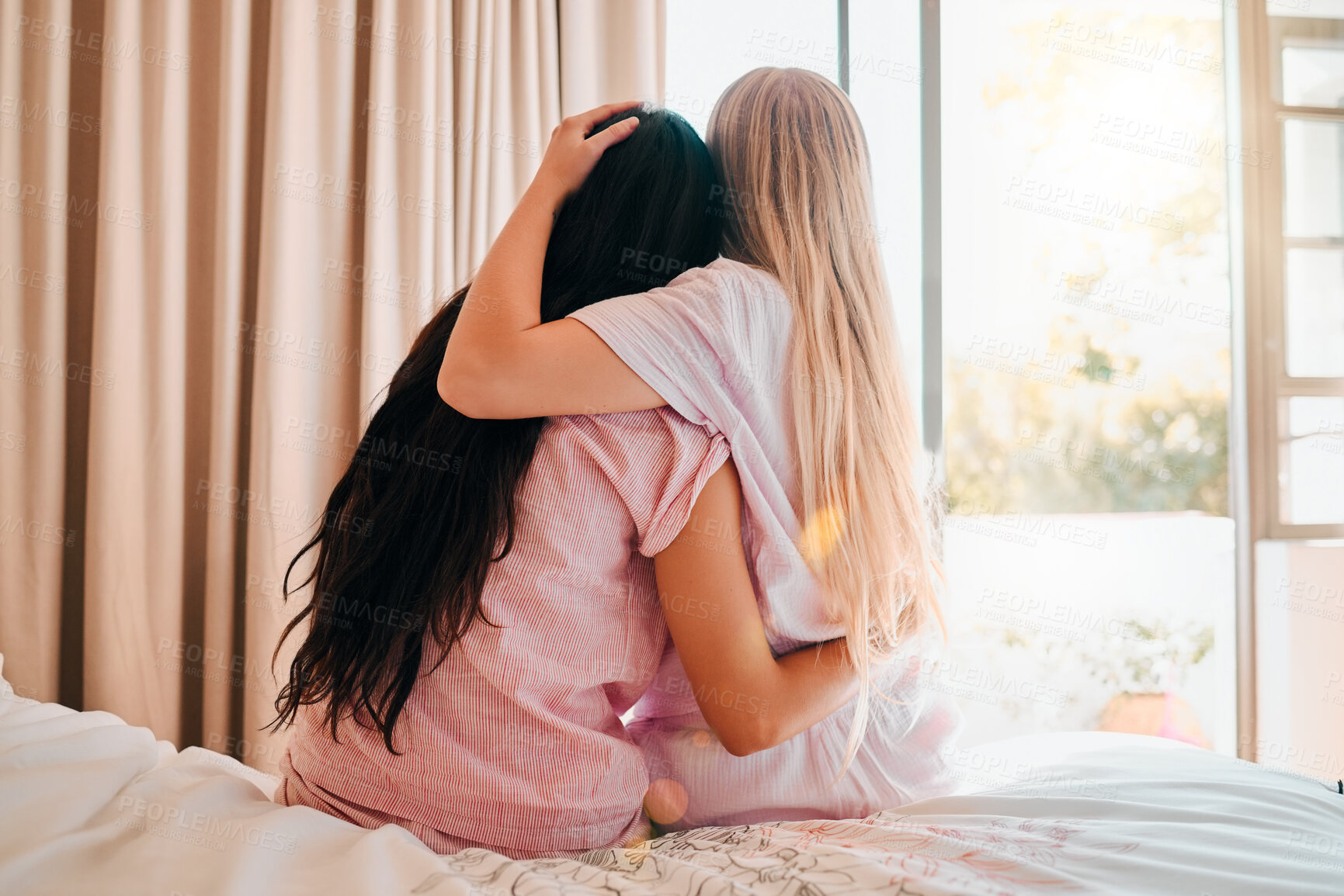 Buy stock photo Love, bedroom and back of friends hugging for comfort, support or care while at a sleepover. Bond, romance and lesbian women couple embracing and spending quality time together in their apartment.