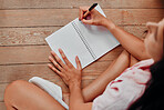 Notebook, writing and planning woman with journal for ideas, inspiration and creativity on wood floor above. Creative young person with mindfulness, healing notes and self care book for writer goals