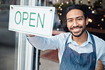 Happy Asian man, small business and smile with open sign on window for service in coffee shop or restaurant. Portrait of male entrepreneur holding billboard or poster for opening retail store or cafe