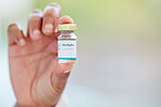 Healthcare, vaccine and hand with monkeypox treatment for cure, breakthrough and innovation on blurred background. Hands, showing and vaccination by woman doctor holding medical booster at hospital