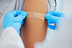 Woman, arm closeup and covid with a plaster and doctor for healthcare and medical injection on arm. Female patient at a clinic or hospital for a vaccine with a bandage for virus, health and wellness