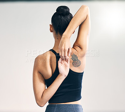 Fitness, back and woman arm stretch in studio for yoga, exercise or training on grey background. Pilates, stretching and behind girl personal trainer at sports center for wellness, workout or warm up