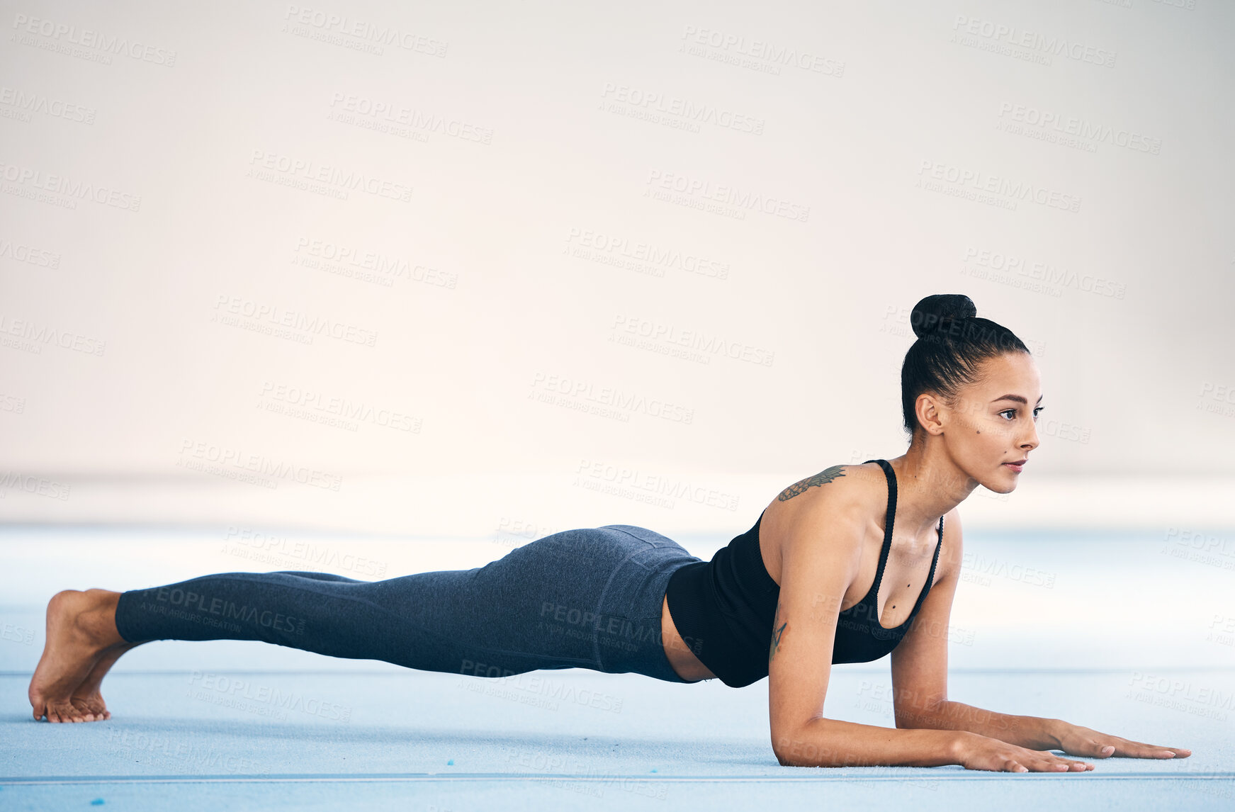 Buy stock photo Fitness, woman and stretching or plank in workout, exercise or training at gym on mockup. Serious, sporty and fit female exercising for healthy wellness or body stretch on floor with copy space