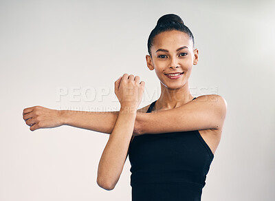 Fitness, portrait and woman arm stretch in studio for yoga, exercise and training on grey background. Pilates, stretching and face of female personal trainer at sports center for wellness or workout