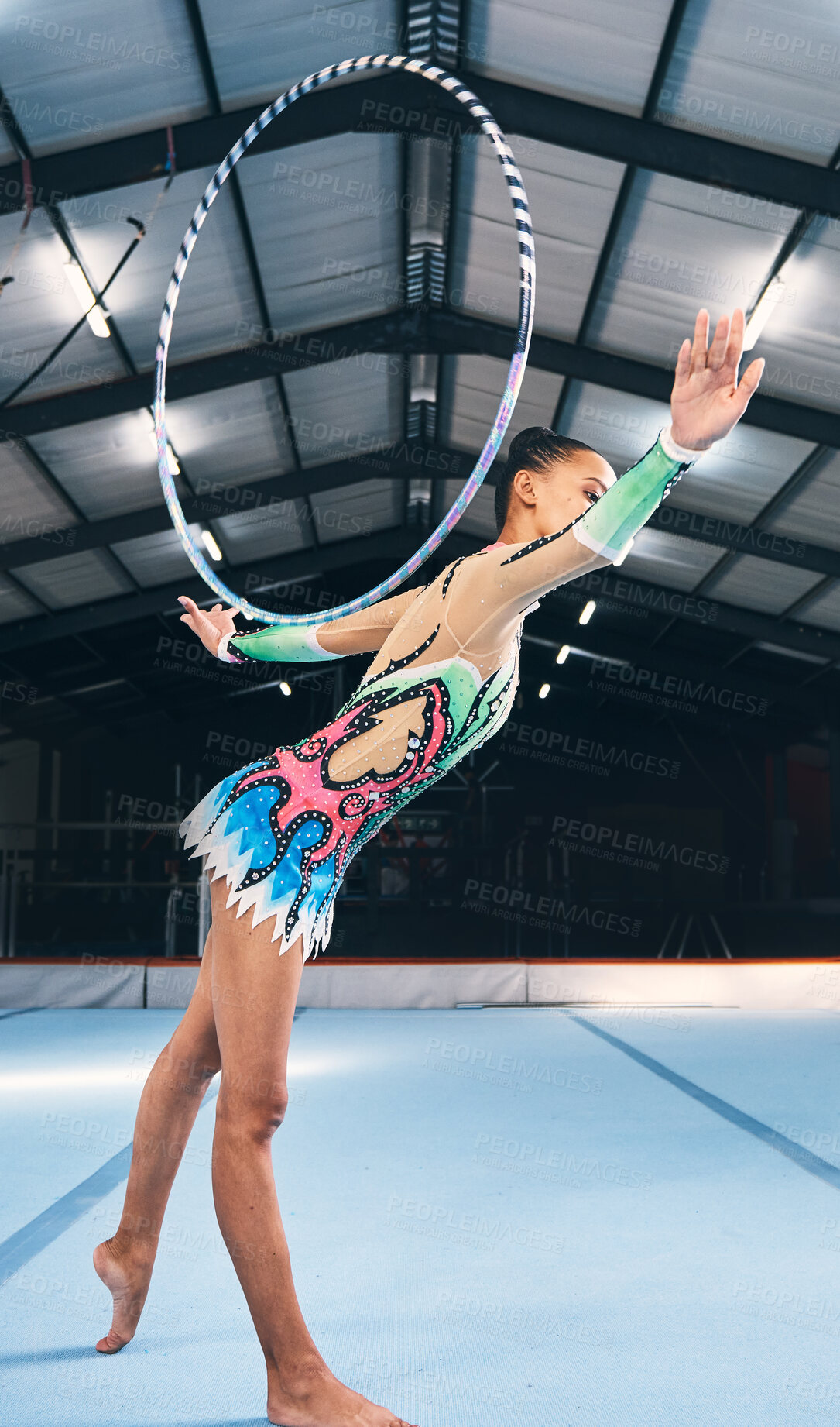 Buy stock photo Woman, gymnastics and hoop for performance, sports training and dancing action in arena. Female, rhythmic movement and dancer with spinning ring for creative talent, solo concert or balance challenge