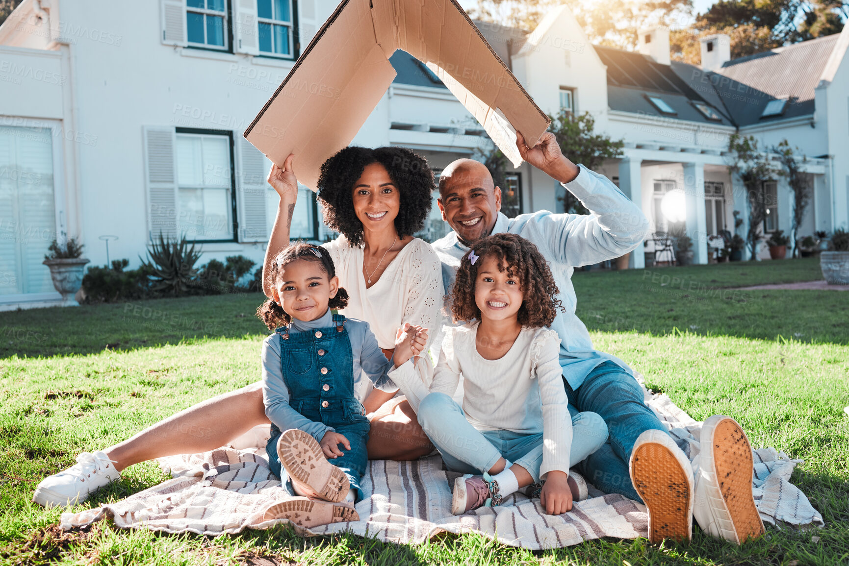 Buy stock photo Cardboard roof, portrait and family relax on the lawn of new home, property or real estate, happy and excited. House, gesture and face of kids with parents relax on grass, proud and mortgage success