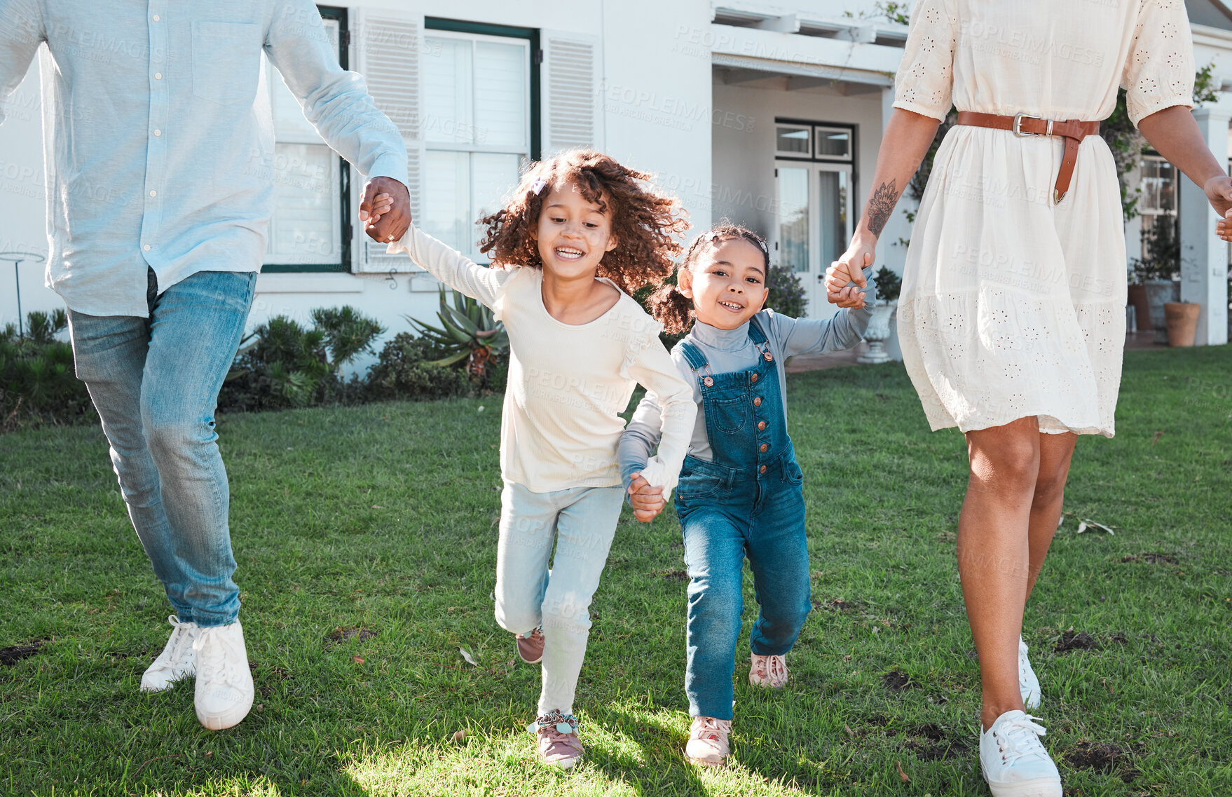 Buy stock photo Family, holding hands and kids running with their parents outdoor in the garden of their home together. Children, fun and daughter siblings playing with their mother and father outside in the yard