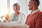 Happy, elderly and a couple talking at breakfast, laughing at a joke and enjoying juice together. Smile, morning and a senior man and woman enjoying a lunch while speaking and bonding at home