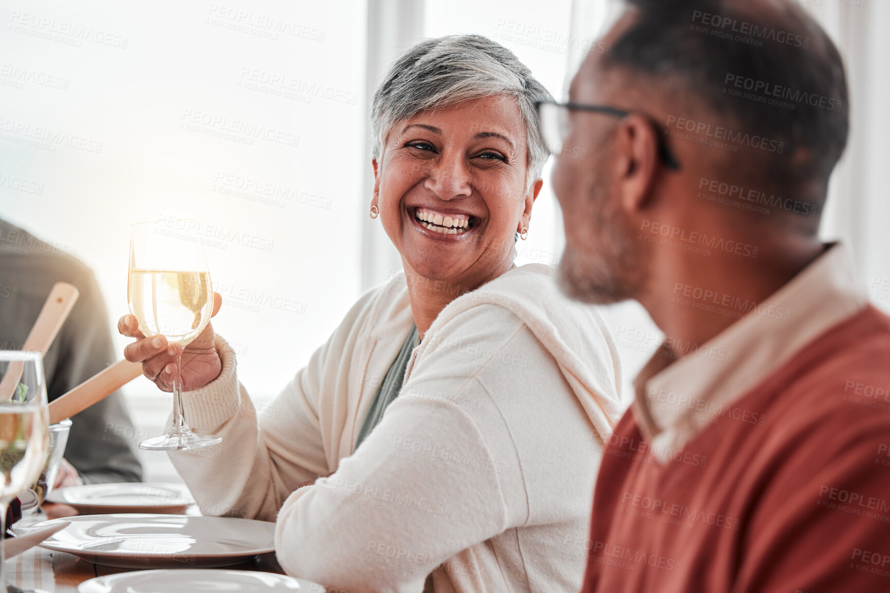 Buy stock photo Happy, smile and couple at lunch in family home, drinking wine and laughing at jokes. Conversation, together and a man and woman speaking with a drink during a dinner with friends in a house