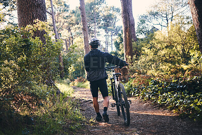 Buy stock photo Nature, fitness and man cyclist with a bicycle for cardio training, health or wellness in the woods. Sports, cycle and male athlete walking with a bike outdoor in the forest to practice for a race.