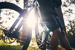 Closeup man, bike and flare in nature, park and sports adventure of freedom, athlete and sunshine. Cycling, bicycle and cyclist on a break outdoor for fitness, cardio exercise and training for action