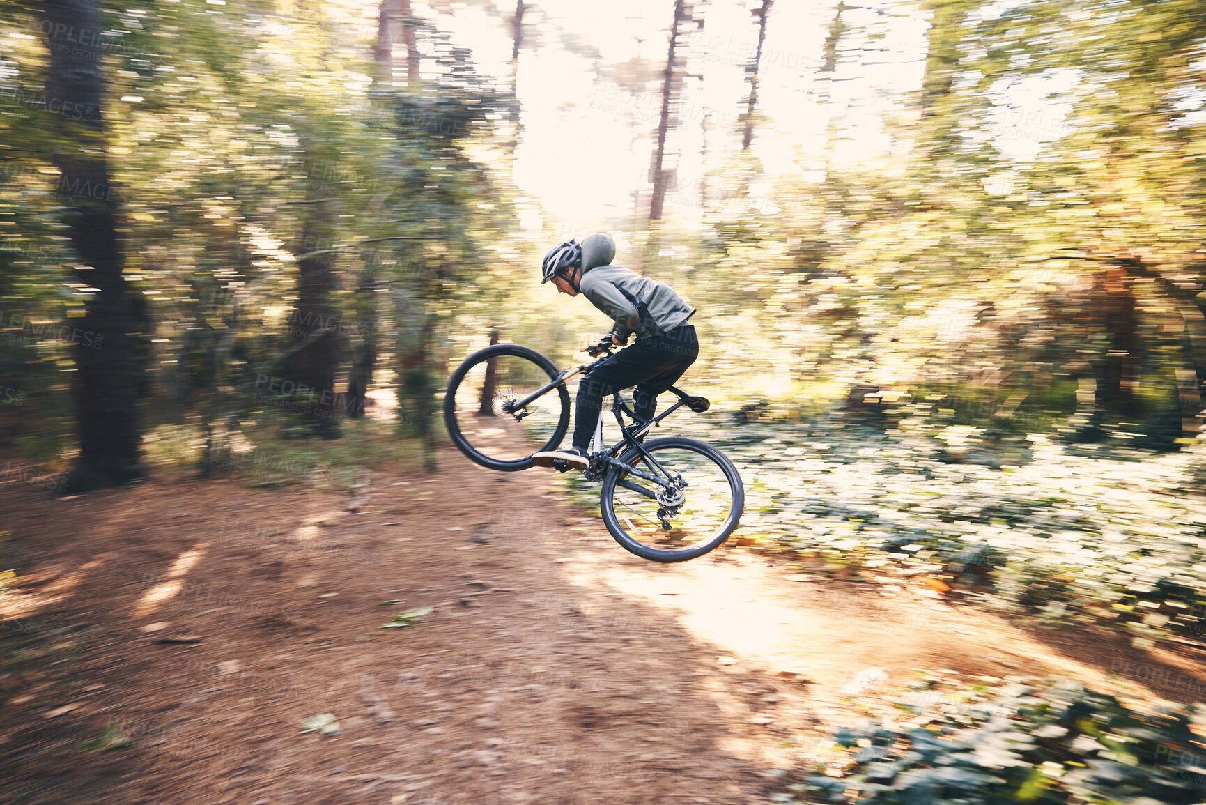 Buy stock photo Cycling, speed and man on a bicycle on a forest road doing training and exercise on a bike. Fast, outdoor trail and athlete on a drive with energy on a nature adventure with fitness on a path