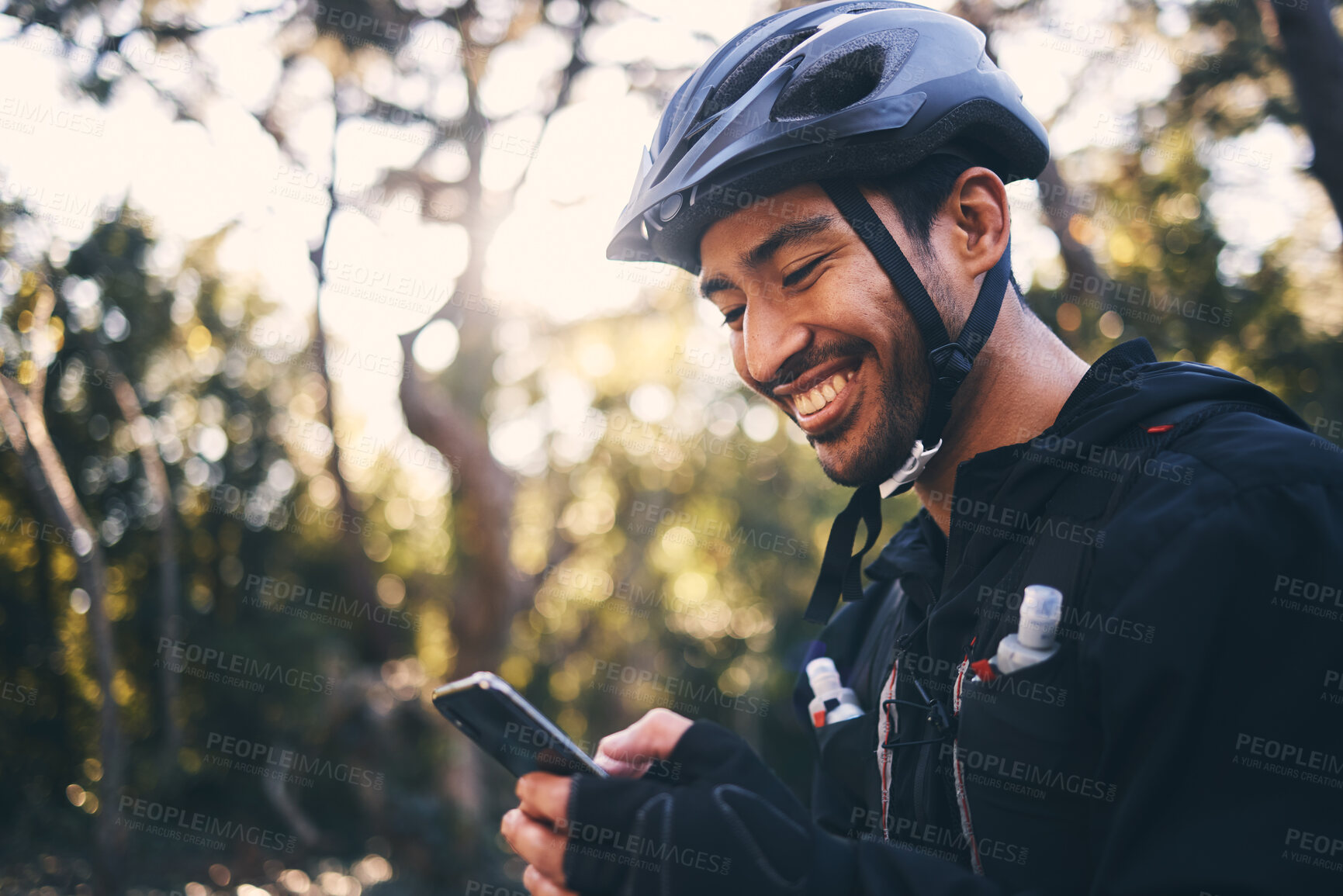 Buy stock photo Cycling, phone and smile with man in nature for search, networking and connection. Relax, happy and social media with male cyclists in forest park for training, sports and internet browsing  