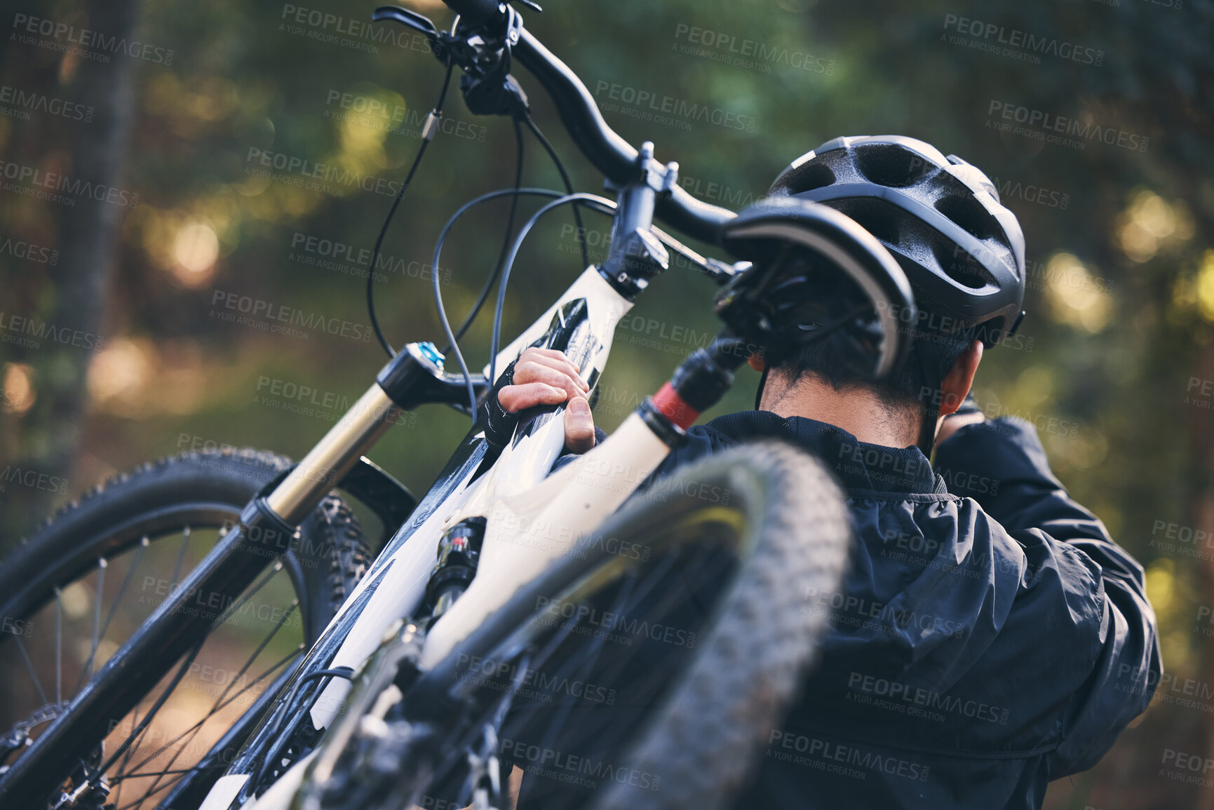 Buy stock photo Forest, fitness and man carrying bicycle in nature with helmet, exercise adventure trail and healthy mindset. Cycling, woods and cyclist with mountain bike in trees for workout, motivation or energy.
