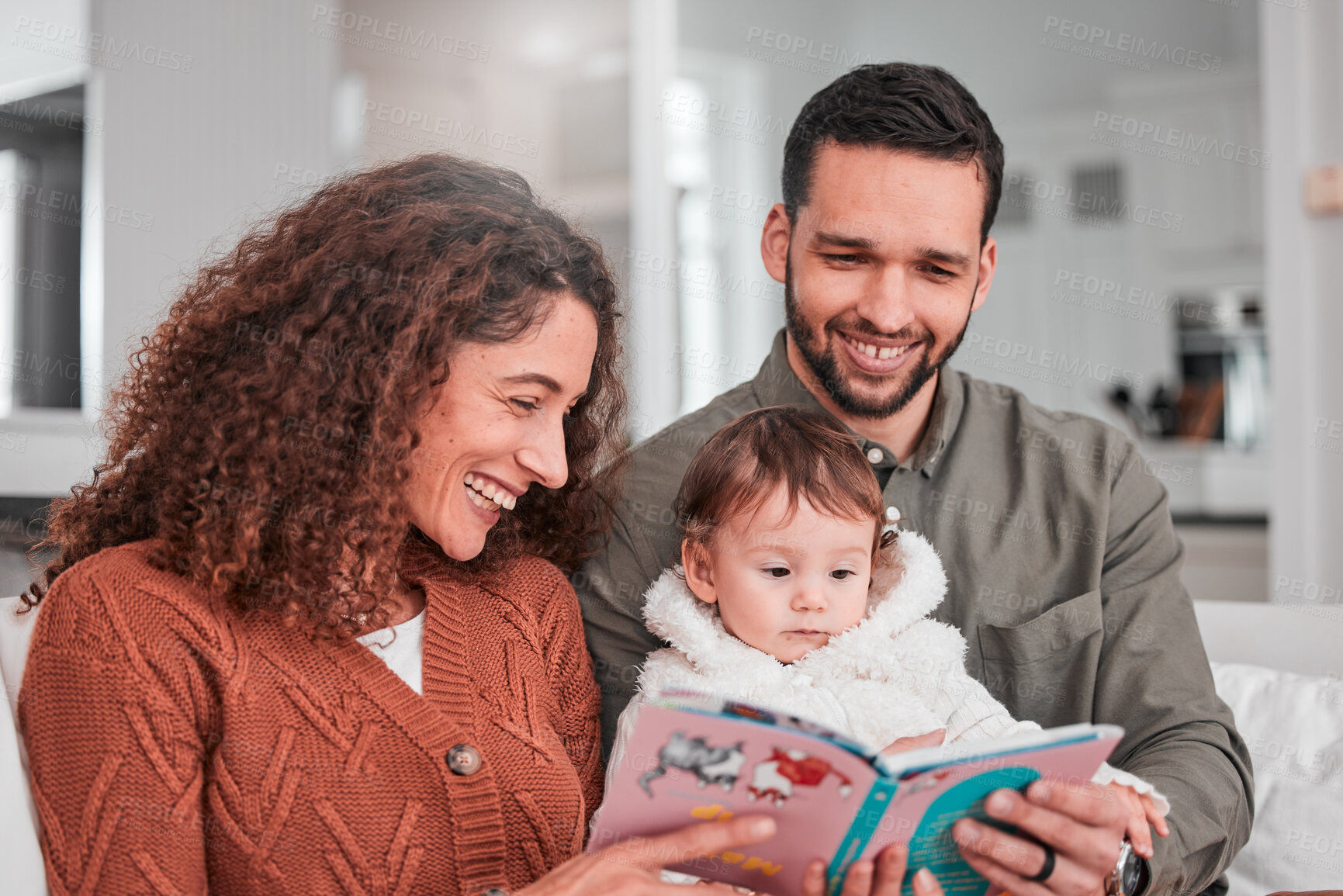 Buy stock photo Parents, baby and reading story on sofa with smile, happiness and bonding with love in living room. Man, woman and child with book for learning, care and relax together on lounge couch in family home