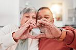 Couple, senior and heart hands in home, love and bonding in retirement together. Romance, hand gesture and elderly man and woman with emoji for care, affection and empathy, commitment and trust.