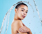 Water drops, skincare and portrait of woman with health, wellness and hygiene isolated on blue studio background. Shower, dermatology and cosmetic beauty glow, model in skin care treatment or routine