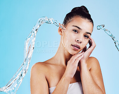 Buy stock photo Portrait, cleaning and woman with water, cosmetics and hygiene on a blue studio background. Face, female and person with clear liquid, morning routine and self care with skincare, beauty and wellness