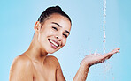 Water drops, skincare and portrait of woman with smile for health, wellness and hygiene with cleaning routine. Shower, cosmetic beauty and happy girl in skin care treatment on blue studio background.