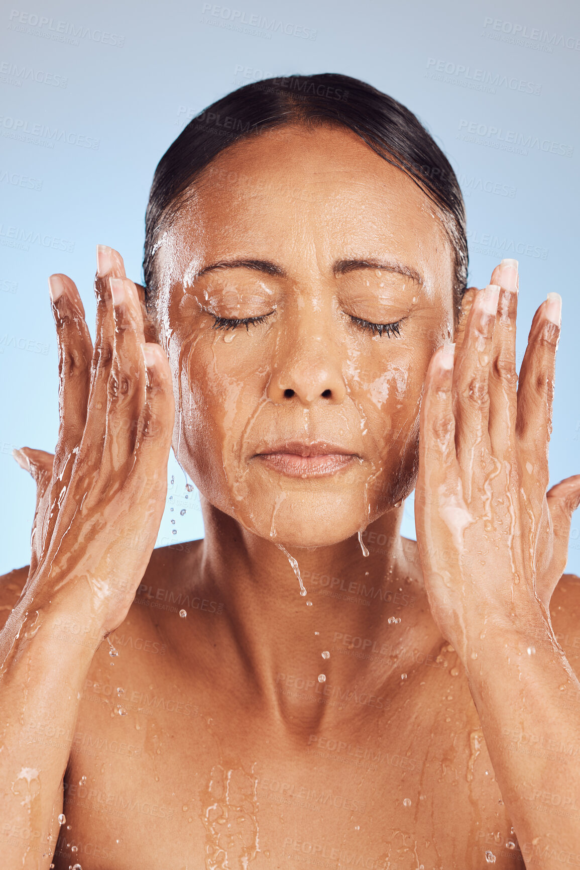 Buy stock photo Old woman, cleaning face and water, beauty and sustainable skincare with antiaging on blue background. Hands, healthy skin and eco friendly dermatology, natural cosmetics and female in studio