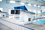Start, platform and water sports with block at swimming pool for championship, jumping and race. Fitness, competition and wellness with lane in indoor arena for exercise, workout and training