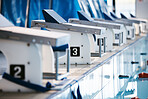 Start, platform and swimming with block at pool for championship, jumping and race. Fitness, competition and wellness with lane in indoor arena for exercise, workout and water sports training