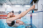 Swimming woman, ready for performance and sports with fitness, health and training for competition at indoor pool. Water sport, Asian athlete and exercise with focus and serious female swimmer
