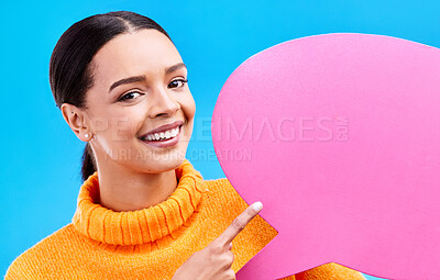 Buy stock photo Speech bubble, smile and portrait of woman pointing to banner in studio for advertising on blue background. Face, happy and girl with poster, mockup and space for social media, announcement or news