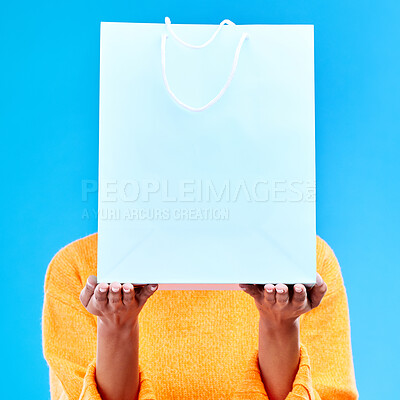 Buy stock photo Shopping, bag and hands of woman on blue background for retail discount, deal and store promotion. Commerce mockup, fashion and girl holding package for advertising, sale news and purchase in studio