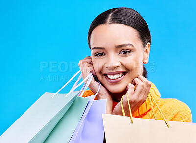 Buy stock photo Shopping bags, studio and woman portrait with a smile and happiness from boutique sale. Happy, customer and female model with store bag and sales choice in isolated blue background with young person