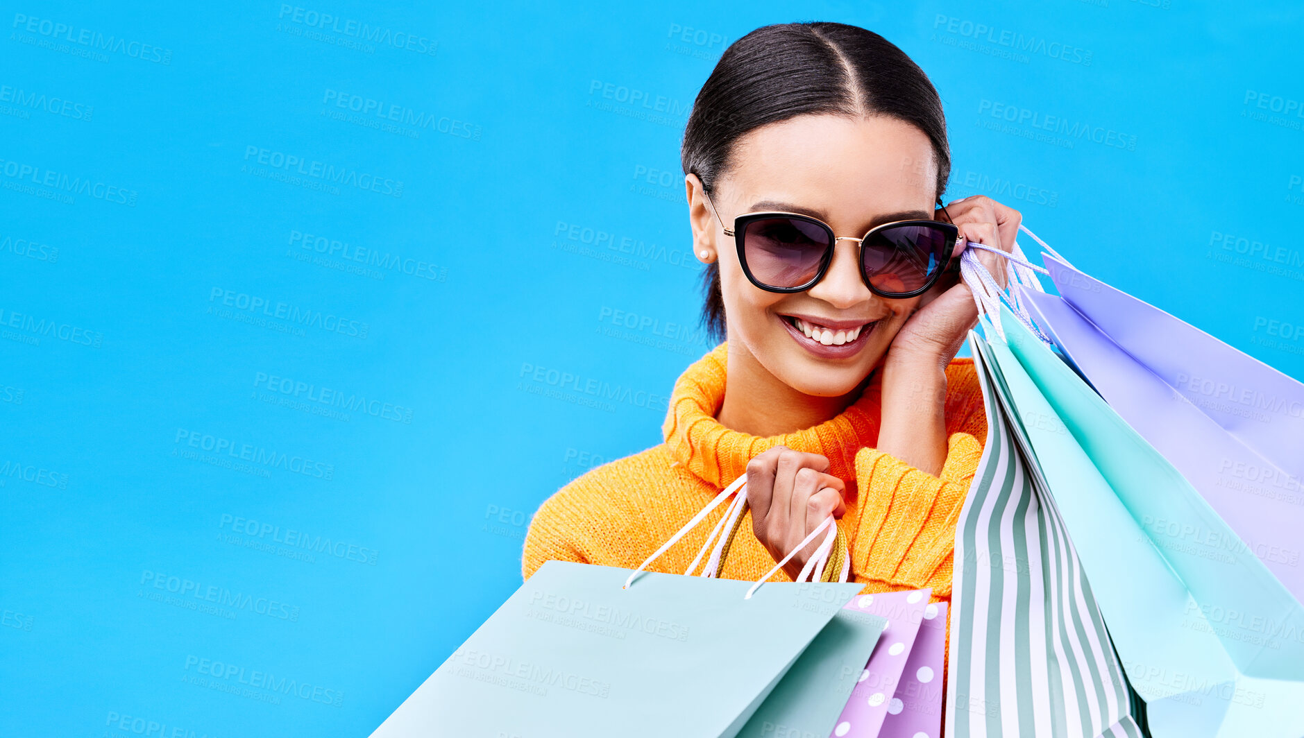 Buy stock photo Shopping gift bags, studio and woman portrait with a smile and happiness from boutique sale. Happy, customer and female model with store bag and sales choice in isolated blue background with mockup