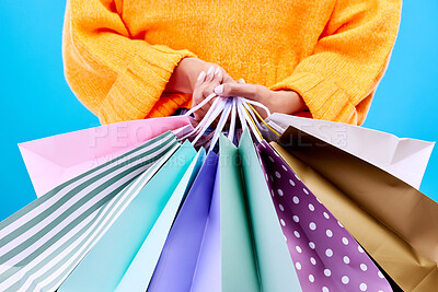 Buy stock photo Shopping bags, studio and woman hands with deal and gifts from boutique sale. Retail, customer and female model with store bag and sales choice in isolated blue background with fashion purchase