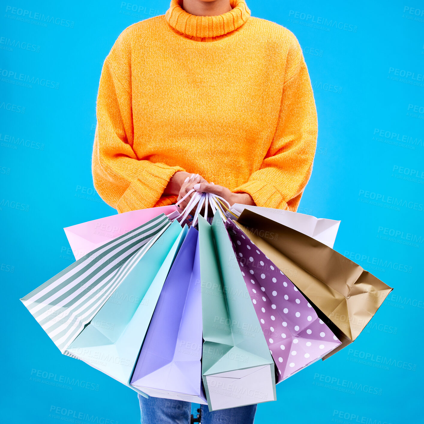 Buy stock photo Woman, hands and shopping bags for purchase, sale or luxury accessories against a blue studio background. Hand of female shopper holding gift bag, buy or discount presents of retail products or items