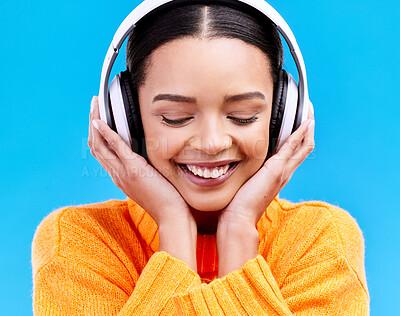 Buy stock photo Headphones, happy music and woman in studio, blue background and backdrop. Smile, female model and listening to radio, streaming album and excited audio connection, sound and subscription to podcast