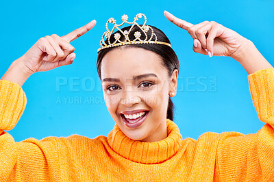 Buy stock photo Point, crown or portrait of woman in studio celebration, princess and birthday party. Smile, beauty and fashion with female tiara on blue background and excited for achievement, winner and prom event