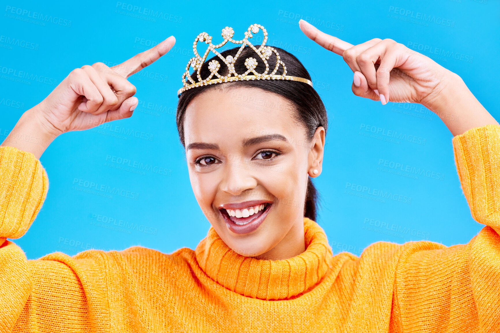 Buy stock photo Point, crown or portrait of woman in studio celebration, princess and birthday party. Smile, beauty and fashion with female tiara on blue background and excited for achievement, winner and prom event