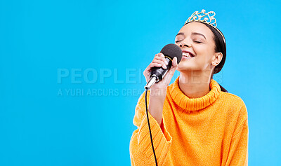 Buy stock photo Singer woman, crown and microphone in studio mockup with smile for singing performance by blue background. Happy gen z girl, model or recording artist mic for karaoke, music and mock up with tiara