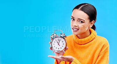 Buy stock photo Woman, alarm clock and annoyed in studio portrait with mockup space by blue background. Gen z girl, student and model with watch for time management, schedule or angry face in mock up by backdrop