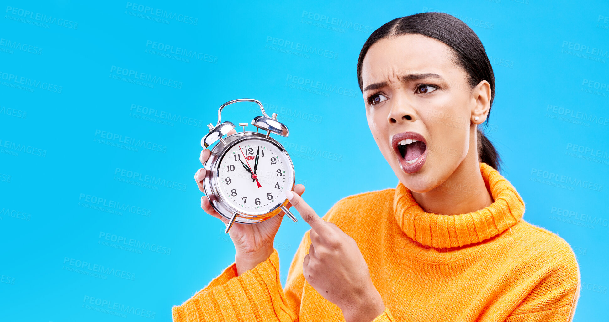 Buy stock photo Frustrated, time and woman with an alarm clock, late and angry against a blue studio background. Female, shouting and person pointing to watch, screaming and schedule with appointment or disagreement