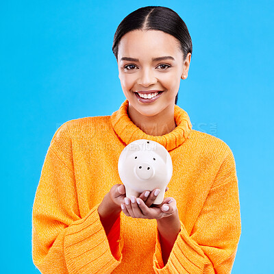 Buy stock photo Happy woman, money and piggy bank for investment, budget or finance against a blue studio background. Portrait of female smile holding savings, cash or coin for profit, investing or financial freedom